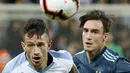 Gelandang timnas Uruguay Brian Lozano berebut bola dengan bek timnas Argentina Nicolas Tagliafico dalam laga persahabatan di Stadion Bloomfield, Tel Aviv, Israel, Senin (18/11/2019). Skor berakhir 2-2, dengan penalti Lionel Messi menghindarkan timnas Argentina  dari kekalahan. (Jack GUEZ/AFP)