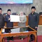 Bupati Garut Rudy Gunawan dan Ketua DPRD Euis Ida Wartiah, tengah menunjukan dokumen persiapan pembentukan DOB Garut Selatan dalam sidang paripurna (Liputan6.com/Jayadi Supriadin)