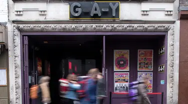 Pejalan kaki melintas di depan bar 'GAY', Soho, London, Senin (27/2). Soho merupakan kawasan yang terkenal sebagai distrik hiburan dan surga bagi para homoseksual setelah dilegalkan sejak 50 tahun lalu. (AFP Photo/ JUSTIN TALLIS)