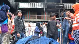 Calon pembeli melihat barang dagangan di depan gedung Pasar Senen pasca kebakaran, Jakarta, Minggu (22/1). Akibat kebakaran yang melanda Pasar Senen pada tanggal 19 Januari lalu, kini pedagang menjual pakaian di bahu jalan. (Liputan6.com/Helmi Affandi)