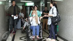 Aktris peran Sheila Marcia menggunakan kursi roda menuju lobi Rumah Sakit Medistra, Jakarta, Selasa (9/5). Saat akan meninggalkan rumah sakit, tampak memar pada mata kiri akibat benturan yang dialami Sheila saat kecelakaan. (Liputan6.com/Herman Zakharia)