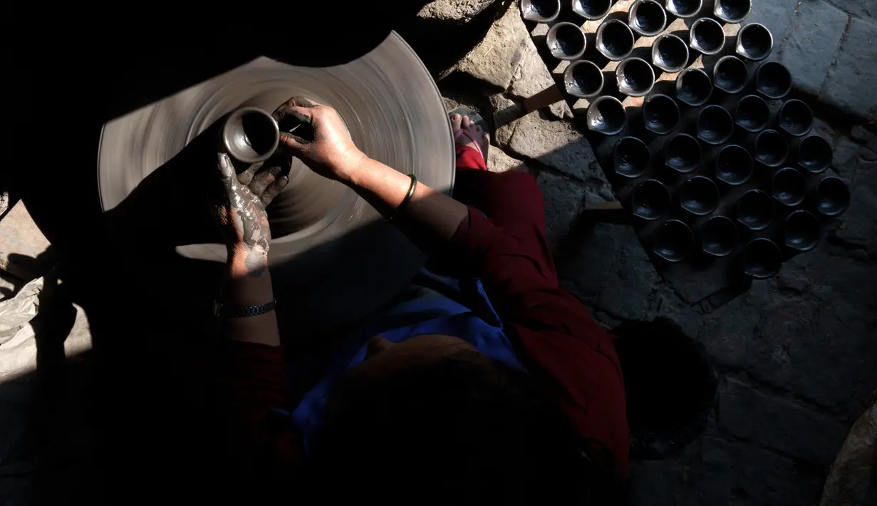 Seorang pembuat tembikar membuat lampu tanah untuk Festival Tihar atau Yama Panchak di Bhaktapur, Nepal, 21 Oktober 2022. Selama festival lima hari yang mirip dengan Festival Diwali di India tersebut, umat Hindu mendekorasi rumah dan tempat ibadah mereka. (AP Photo/Niranjan Shrestha)