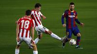 Gelandang Athletic Bilbao, Unai Vencedor (tengah) berebut bola dengan penyerang Barcelona Lionel Messi pada pekan ke-21 Liga Spanyol 2020/21 di Stadion Camp Nou, Senin (1/2/2021) dini hari WIB. Barcelona sukses mengalahkan Athletic Bilbao dengan skor tipis 2-1. (AP Photo/Joan Monfort)