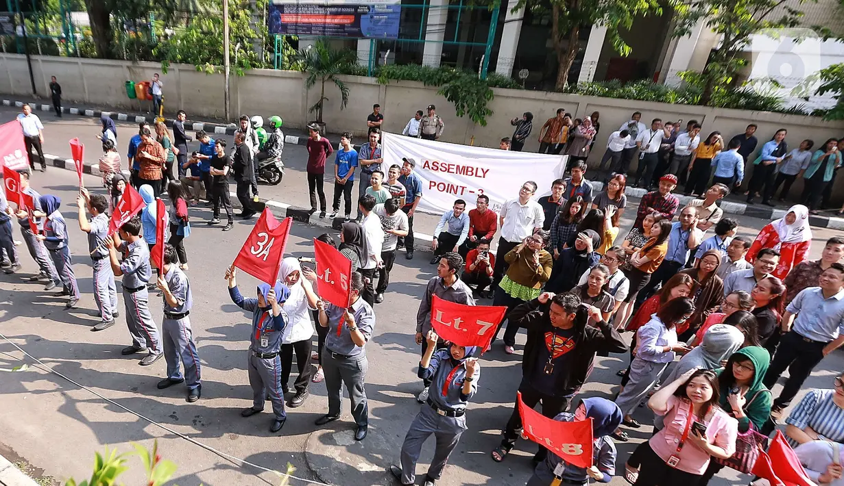 Sejumlah karyawan menyaksikan simulasi evakuasi kebakaran di Plaza Semanggi, Jakarta, Rabu (11/12/2019). Simulasi  tersebut dilakukan untuk memberikan pelatihan dan kesigapan menghadapi situasi darurat seperti kebakaran, gempa bumi dan lain-lain. (Liputan6.com/Angga Yuniar)