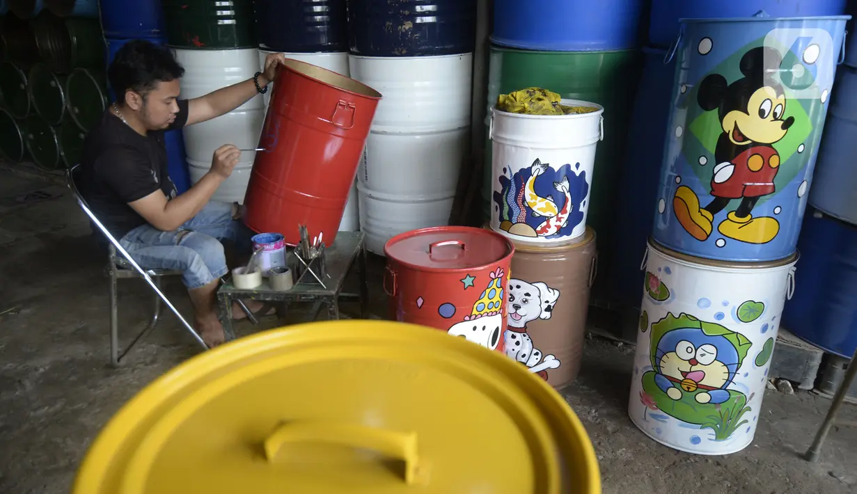 Faiz (21) melukis tong sampah dengan gambar tokoh kartun di Setu, Tangerang Selatan, Banten, Kamis (1/10/2020). Faiz mengecat ulang tong bekas dan melukisnya dengan tokoh-tokoh kartun, lalu menjualnya dengan harga Rp 85 hingga 120 ribu per unit. (merdeka.com/Dwi Narwoko)
