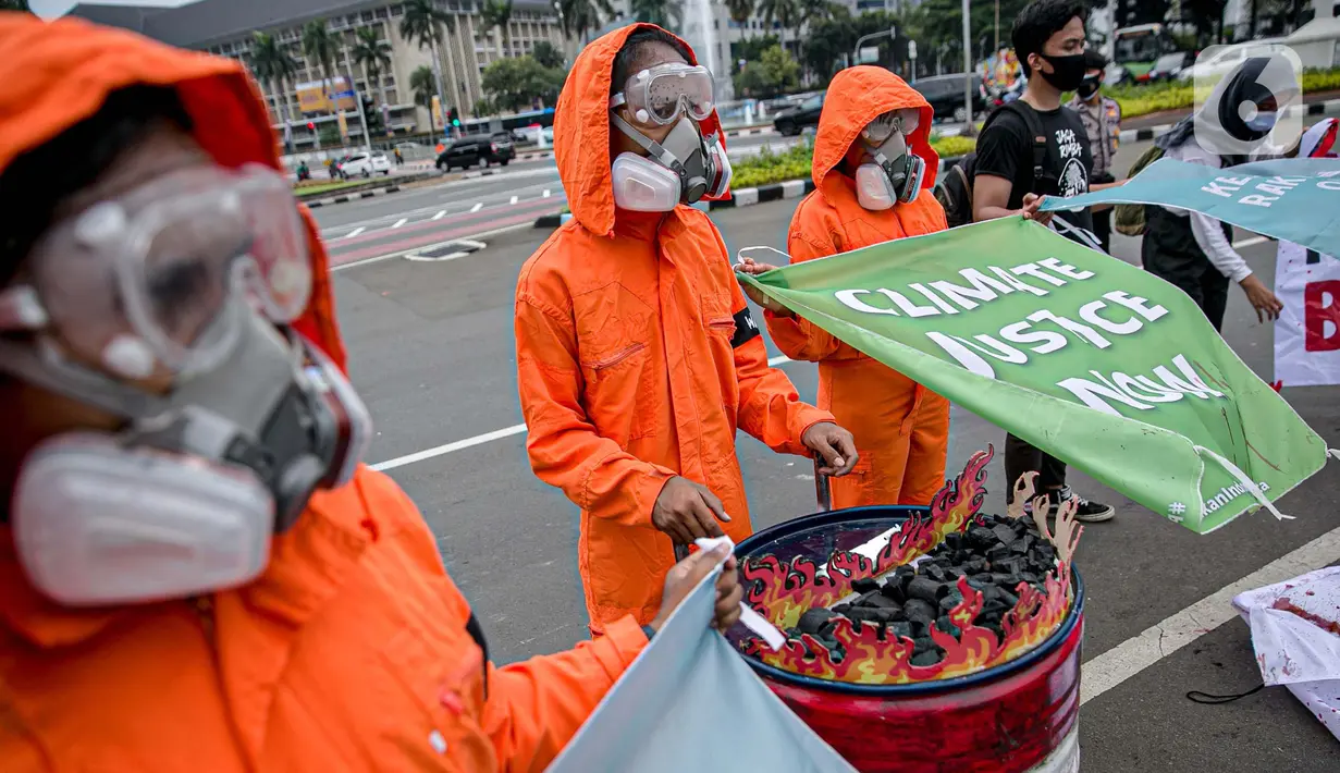 Sejumlah aktivis melakukan teatrikal dengan menyiramkan darah di tubuhnya saat aksi serentak desak Presiden Jokowi deklarasikan Darurat Iklim di kawasan Patung Kuda, Jakarta, Jumat (19/3/2021). Aksi serentak di beberapa lokasi itu untuk menuntut deklarasi darurat iklim. (Liputan6.com/Faizal Fanani)
