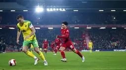 Pemain Liverpool Takumi Minamino (kanan) berebut bola dengan pemain Norwich City Ben Gibson pada pertandingan sepak bola Piala FA di Stadion Anfield, Liverpool, Inggris, 2 Maret 2022. Liverpool menang 2-1. (AP Photo/Jon Super)