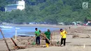 Sukarelawan yang berasal dari warga lokal membersihkan sampah yang berserakan akibat terbawa ombak pasang di kawasan Pantai Citepus, Pelabuhan Ratu, Sukabumi, Jumat (4/1). (Merdeka.com/Arie Basuki)