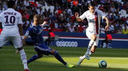 Gelandang PSG, Angel Di Maria, berusaha melewati pemain Strasbourg pada laga Liga 1 Prancis di Stadion Parc des Princes, Sabtu (14/9). PSG menang 1-0 atas Strasbourg. (AP/Francois Mori)