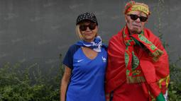 Sepasang suami istri pendukung Portugal dan Prancis foto bersama sebelum menyaksikan laga final Piala Eropa (Bola.com/Vitalis Yogi Trisna)