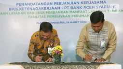 Direktur Utama BPJS Ketenagakerjaan (BPJAMSOSTEK) Anggoro Eko Cahyo (kanan) dan Direktur Utama Bank Aceh Haizir Sulaiman (kiri) saat menandatangani PKS terkait Penyediaan Layanan dan Jasa Perbankan dalam Rangka Pemberian MLT di Jakarta, Kamis (24/03/2022). (Liputan6.com/Fery Pradolo)