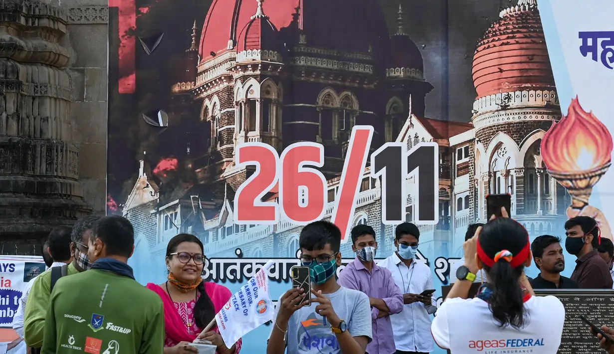 Orang-orang berkumpul di dekat Gerbang India untuk memberikan penghormatan kepada para korban serangan teroris 2008 pada peringatan 13 tahun di Mumbai (26/11/2021). Dalam peringatan itu mereka akan menggelar doa, peletakan karangan bunga, dan melakukan aksi damai. (AFP/Punit Paranjpe)
