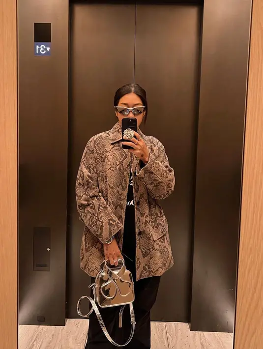 Momen mirror selfie gaya keren Peggy Gou. Ia kenakan inner hitam, ditumpuknya dengan jaket bermotif kulit ular, dan celana panjang hitam.  [Foto: Instagram/peggygou_]