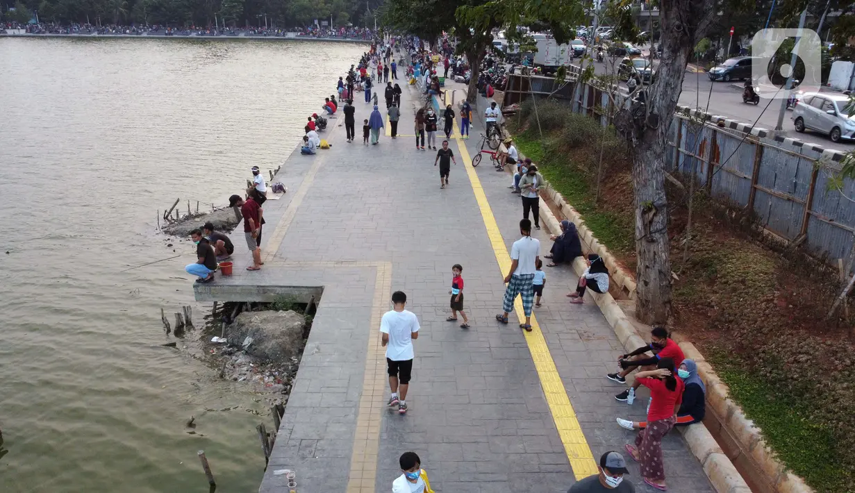 Foto udara memperlihatkan aktivitas warga di pedestrian Danau Sunter, Jakarta, Sabtu (27/6/2020). Beragam aktivitas dilakukan warga sambil menikmati waktu sore di area Danau Sunter, Jakarta. (Liputan6.com/Helmi Fithriansyah)