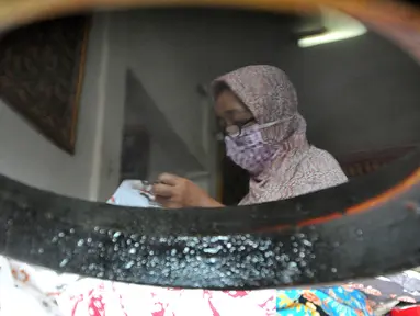 Warga menyelesaikan pembuatan batik di sentra batik Depok Tradjumas, Kamis (24/2/2022). Produksi Batik Depok kembali menggeliat setelah diberlakukannya pembelajaran tatap muka (PTM) Kota Depok di mana murid SD dan SMP menggunakan seragam batik produksi mereka. (merdeka.com/Arie Basuki)