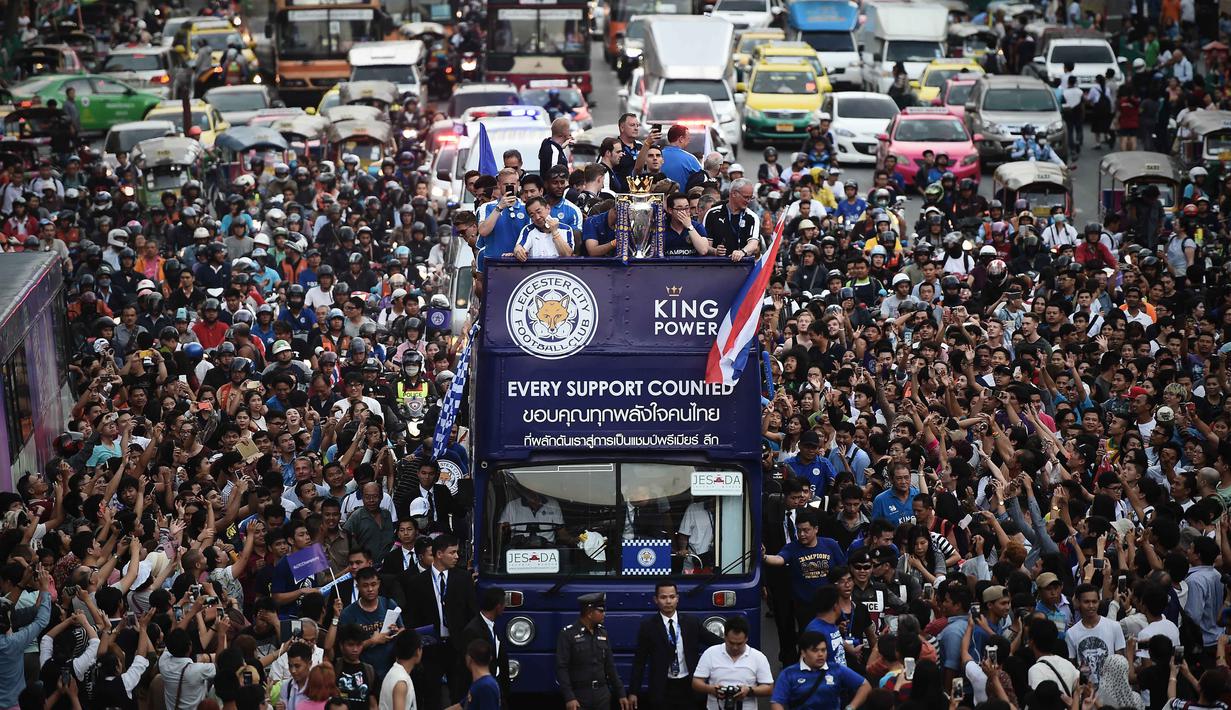 Warga Bangkok menyambut tim Leicester City fsaat parade bersama trofi Liga Inggris 2015/2016 di Bangkok, (19/5/2016). (AFP/Lillian Suwanrumpha)