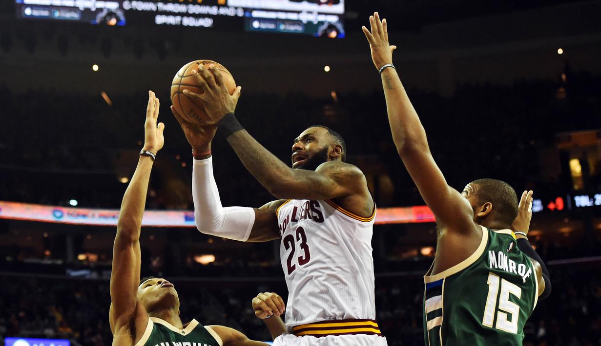 Pemain Cleveland Cavaliers, LeBron James (tengah)  melewati hadangan dua pemain  Milwaukee Bucks pada laga NBA di Quicken Loans Arena, Cleveland, (21/12/2016). Cavaliers menang 113-102. (Reuters/Ken Blaze-USA TODAY Sports)