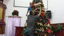 Pekerja menghias pohon Natal di Gereja Tugu, Jakarta, Senin (23/12/2019). Sejumlah perlengkapan ibadah telah disiapkan untuk menyambut Natal. (Liputan6.com/Herman Zakharia)
