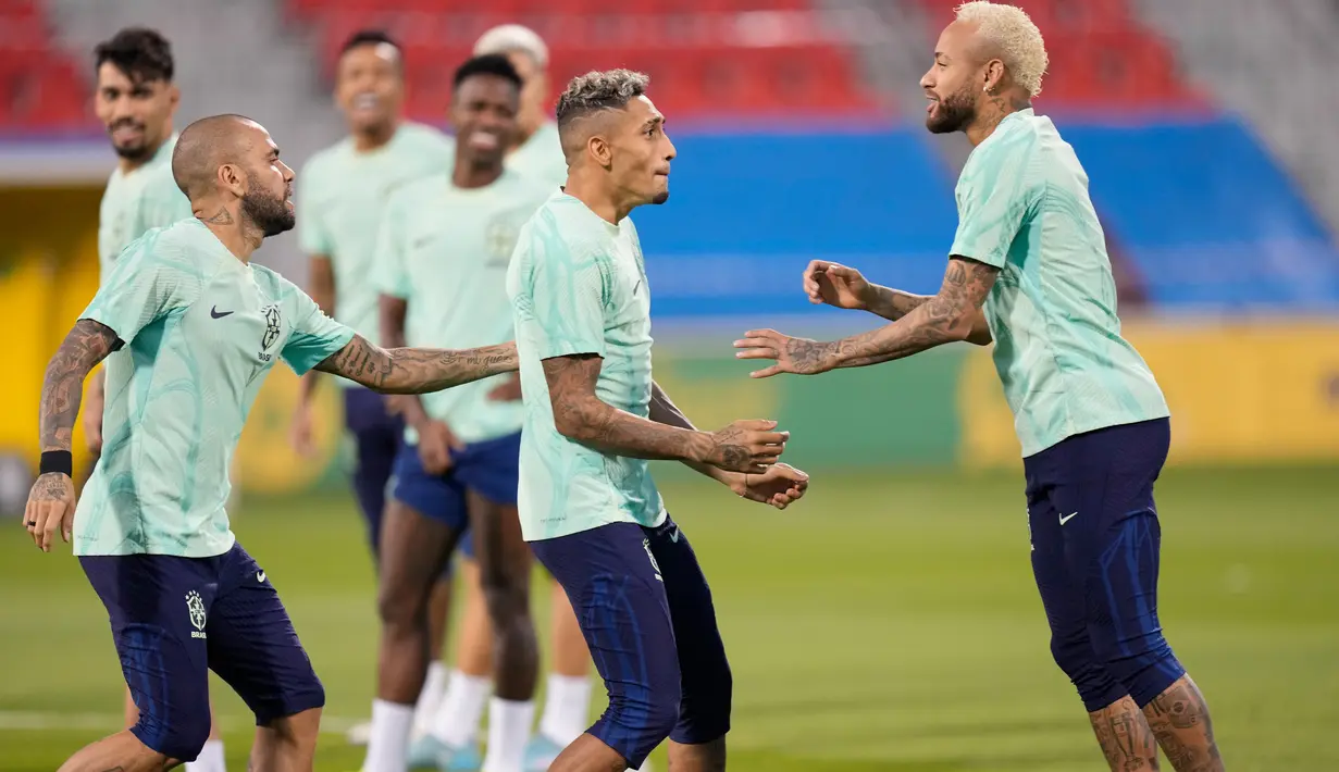 Pemain Brasil Neymar (kanan), Raphinha (tengah), dan Dani Alves bercanda saat sesi latihan di Stadion Grand Hamad, Doha, Qatar, 8 Desember 2022. Brasil akan menghadapi Kroasia dalam pertandingan perempat final Piala Dunia 2022 pada 9 Desember. (AP Photo/Andre Penner)