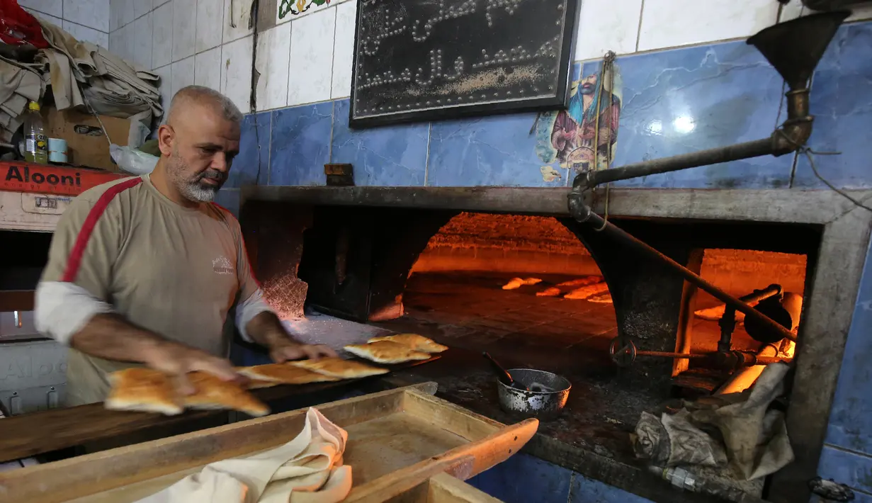 Seorang tukang roti Irak menyiapkan roti isi selama bulan suci Ramadan di toko rotinya di sebuah pasar populer di Baghdad (24/5/2019). Baghdad adalah kota terbesar kedua di Asia Barat Daya setelah Teheran, dengan populasinya pada 2003 diperkirakan mencapai 5.772.000. (AFP Photo/Ahmad Al-Rubaye)