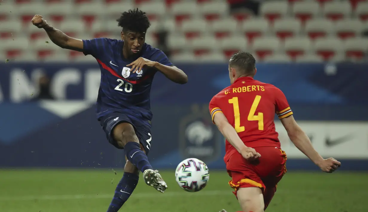 Striker Prancis, Kingsley Coman (kiri) melepaskan tendangan yang coba diblok bek Wales, Connor Roberts dalam laga uji coba menjelang berlangsungnya Euro 2020 di Allianz Riviera Stadium, Nice, Rabu (2/6/2021). Prancis menang 3-0 atas Wales. (AP/Daniel Cole)