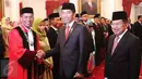 Presiden Joko Widodo dan Wapres Jusuf Kalla memberi selamat kepada Hakim (MK), Saldi Isra usai pelantikan di Istana Negara, Jakarta, Selasa (11/4). Guru Besar Universitas Andalas Padang Saldi Isra dilantik sebagai hakim. (Liputan6.com/Angga Yuniar)