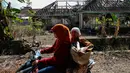 Warga melintas di depan rumah yang akan terkena dampak penggenangan Waduk Jatigede di Desa Cipaku, Sumedang, Jawa Barat, Senin (31/8/2015). Beberapa warga masih ada yang bertahan karena belum tuntasnya soal ganti rugi. (Liputan6.com/Faizal Fanani)