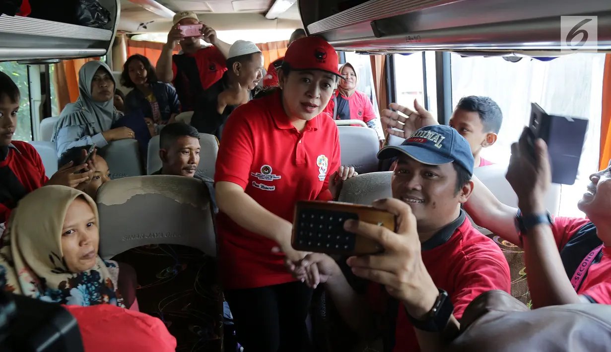 Ketua DPP PDIP nonaktif, Puan Maharani berswafoto dengan peserta mudik gratis PDIP di Kantor DPP PDIP, Jakarta, Selasa (12/6). Kota tujuan mudik gratis seperti Jawa Barat dan Jawa Tengah. (Liputan6.com/JohanTallo)