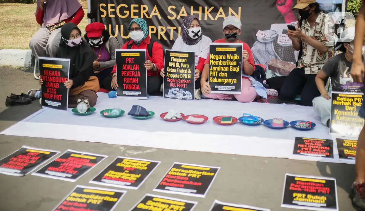 Sejumlah anggota aliansi Mogok Makan Untuk Undang Undang Perlindungan Pekerja Rumah Tangga (UU PPRT) membentangkan poster saat aksi di depan Gedung DPR, Jakarta, Senin (14/8/2023). (Liputan6.com/Faizal Fanani)