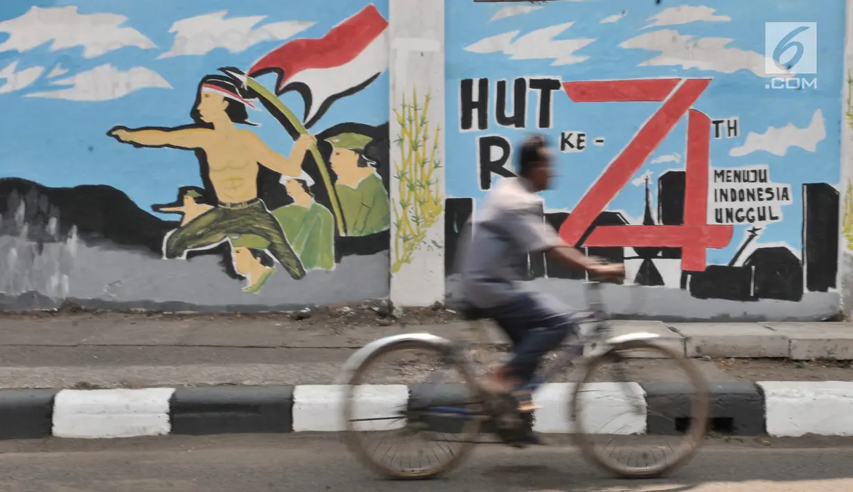 Pesepeda melintas di depan mural bertema Kemerdekaan Indonesia yang dibuat PPSU Kelurahan Pondok Bambu di Jalan Kolonel Sugiono, Jakarta, Selasa (13/8/2019). Mural dalam rangka menyambut Hari Kemerdekaan pada 17 Agustus itu sekaligus mempercantik jalanan Ibu Kota. (merdeka.com/Iqbal S Nugroho)