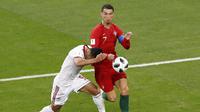 Kapten Portugal, Cristiano Ronaldo, berduel dengan pemain bertahan Iran, Omid Ebrahimi, dalam laga lanjutan Grup B Piala Dunia 2018 di Mordovia Arena, Saransk, Selasa (26/6/2018) dini hari WIB. (AP Photo/Darko Bandic)
