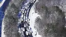 Pengemudi menunggu lalu lintas dibersihkan ketika mobil dan truk terdampar di bagian Interstate 95 di Carmel Church, Virginia, Selasa (4/1/2022). Salju tebal menimbulkan kekacauan di Washington, DC, menyebabkan ratusan pengemudi terdampar di jalan raya utama di Virginia. (AP Photo/Steve Helber)
