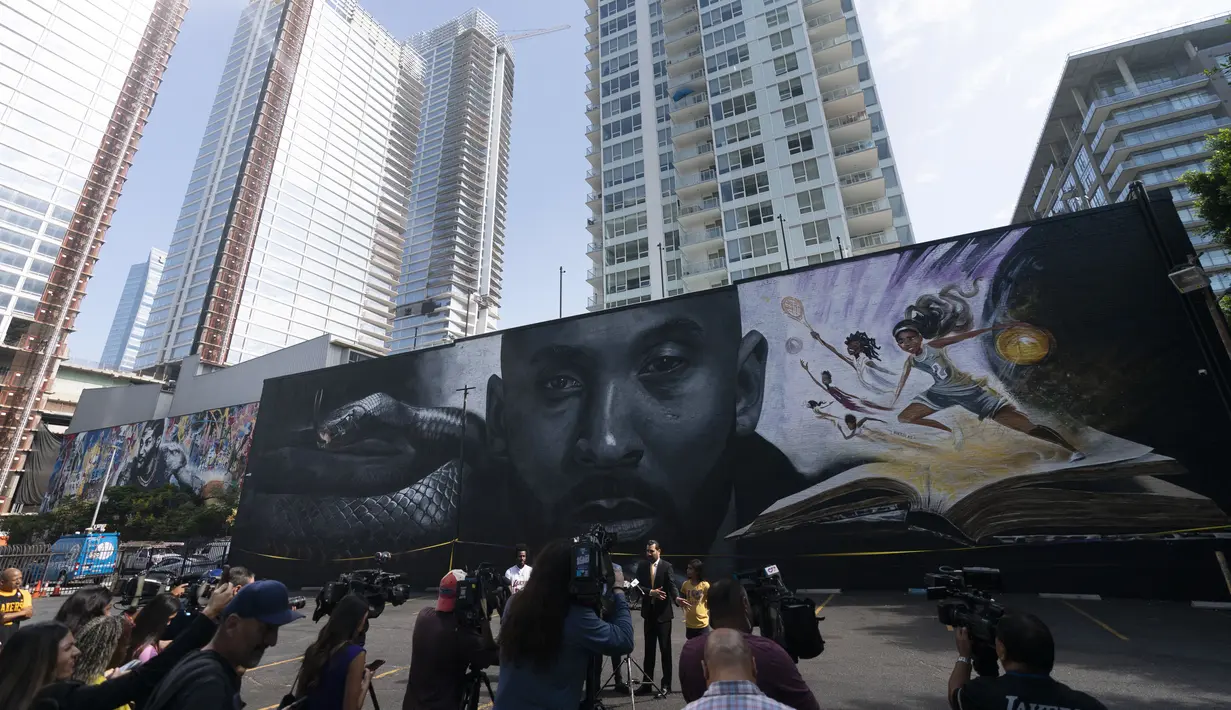 Anggota media berkumpul di depan mural yang menggambarkan Kobe Bryant dan putrinya, Gianna, selama konferensi pers di Los Angeles, Rabu, 24 Agustus 2022. Mural, yang dilukis oleh seniman jalanan Portugis Odeith dan seniman dan ilustrator kontemporer Amerika Nikkolas Smith tersebut untuk merayakan Kobe Bryant Day. (AP Photo/Jae C. Hong)