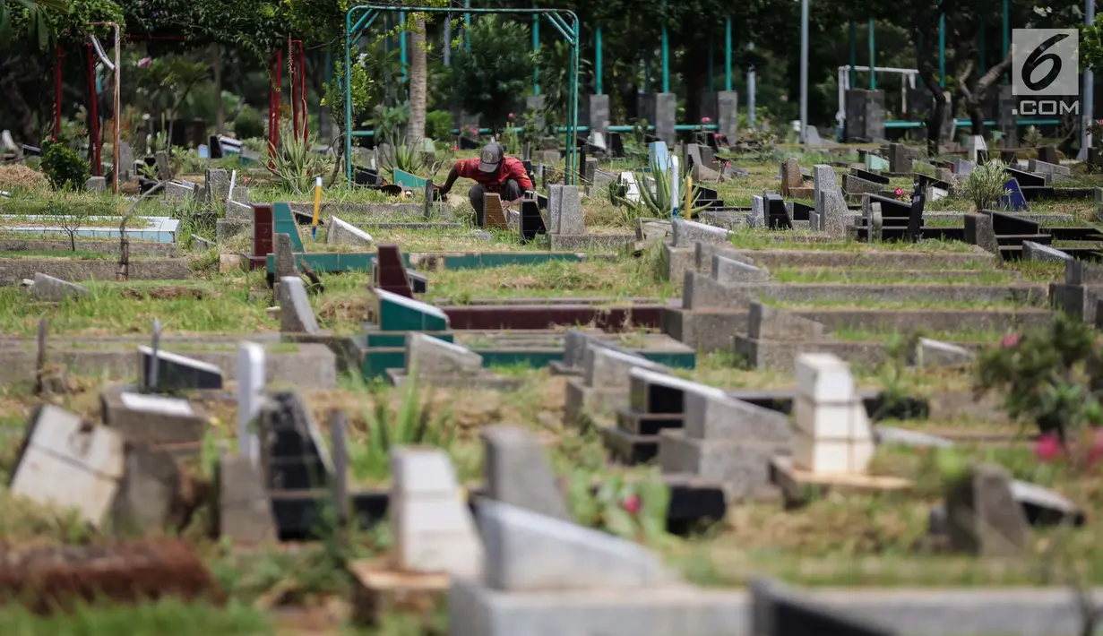 Petugas makam membersihkan area pemakaman di Tempat Pemakaman Umum (TPU) Utan Jati, Jakarta, Kamis (11/1). Pemprov DKI Jakarta menyiapkan anggaran Rp 400 miliar untuk pengadaan lahan makam TPU pada tahun ini. (Liputan6.com/Faizal Fanani)
