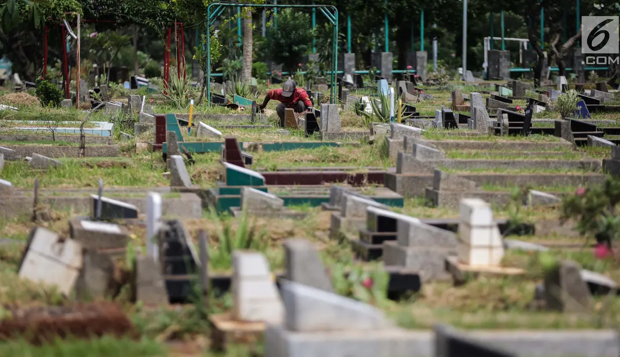 Petugas makam membersihkan area pemakaman di Tempat Pemakaman Umum (TPU) Utan Jati, Jakarta, Kamis (11/1). Pemprov DKI Jakarta menyiapkan anggaran Rp 400 miliar untuk pengadaan lahan makam TPU pada tahun ini. (Liputan6.com/Faizal Fanani)