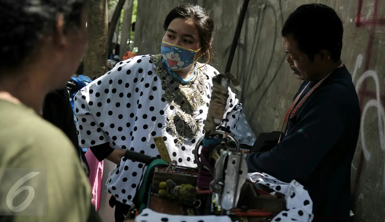 Menjelang hari raya Idul Fitri, penjahit 'vermak levis' keliling mulai kebanjiran rezeki, Jakarta, Senin (4/7). Warga banyak berdatangan untuk memotong atau mengecilkan pakaian Lebaran. (Liputan6.com/Yoppy Renato)
