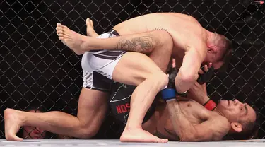 Michael Chandler (kiri) melawan Tony Ferguson pada pertarungan kelas ringan putra UFC 274 di Footprint Center, Phoenix, Arizona, Amerika Serikat, 7 Mei 2022. Chandler dinyatakan menang KO atas Ferguson. (Christian Petersen/Getty Images/AFP)