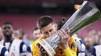 Kiper Tottenham Guglielmo Vicario mencium trofi Liga Europa&nbsp;setelah mengalahkan Manchester United di San Mames,&nbsp;Kamis (22/5/2025). (AP Photo/Jose Breton)