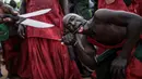 Seorang warga etnis Joles menggoreskan pisau ke lidahnya saat menunjukan kekuatan sihir di Bikama, Gambia (24/11). Kekuatan itu berasal dari air spiritual yang membuat mereka kebal dari senjata tajam. (AFP/Marco Longari)