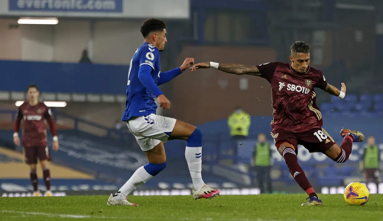 Gelandang Leeds United, Raphinha (kanan), melepaskan tendangan yang menghasilkan gol di hadapan gelandang Everton, Ben Godfrey, dalam laga lanjutan Liga Inggris 2020/21 melawan Everton di Goodison Park Stadium, Sabtu (28/11/2020) waktu setempat. Leeds United menang 1-0 atas Everton. (AFP/Clive Bruns