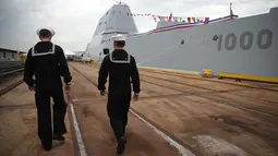 Dua pelaut berjalan disamping Kapal USS Zumwalt di Baltimore, Maryland, AS (13/10). Kapal senilai USD 4,4 miliar ini memiliki bentuk yang gagah dan dilengkapi sistem persenjataan canggih. (AFP Photo/Mark Wilson)