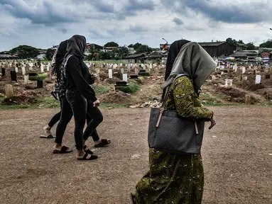 Warga berziarah ke makam anggota keluarga yang dikebumikan dengan protokol Covid-19 di TPU Tegal Alur, Jakarta, Kamis (14/1/2021). Kepala Satuan Pelaksana TPU Tegal Alur Wawan Wahyudi mengungkapkan blok pemakaman muslim khusus jenazah terpapar Covid-19 telah penuh. (merdeka.com/Iqbal S. Nugroho)