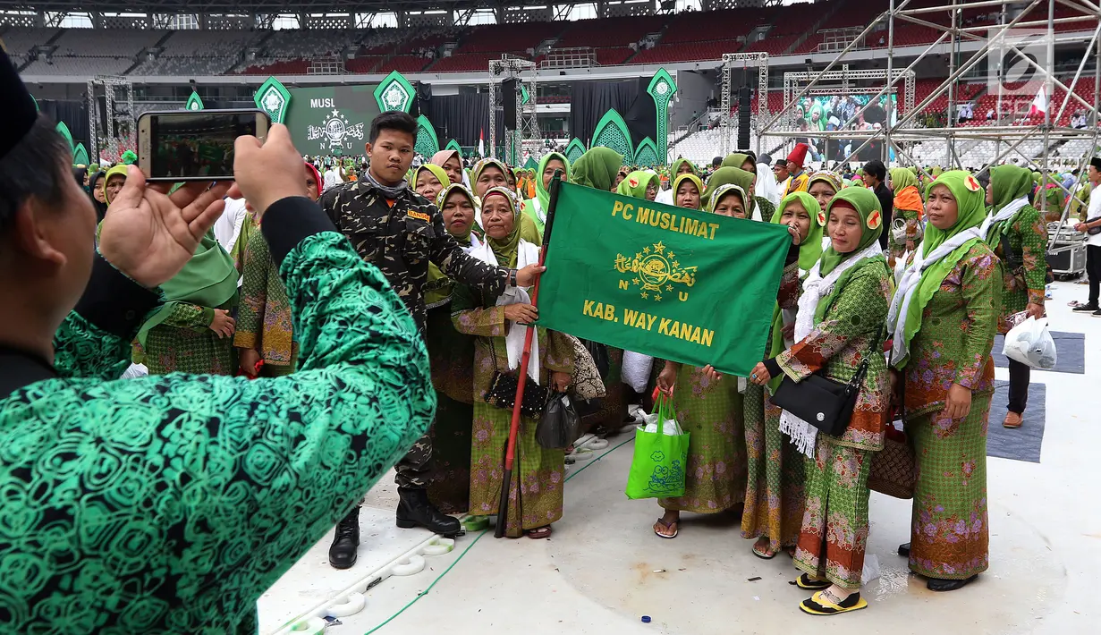 Kader Muslimat NU foto dengan gambar Ketum PP Muslimat NU Khofifah Indar Parawansa dan Ketua Panitia Harlah ke-73 Muslimat NU Zannuba Ariffah Chafsoh Rahman Wahid atau Yenny Wahid di SUGBK, Jakarta, Minggu (27/1). (Liputan6.com/Johan Tallo)