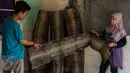 Pekerja saat akan menjemur kulit ular untuk pembuatan hasil kerajinan tangan di bengkel kerja, Cibitung, Jawa Barat, Jumat (24/3). Bahan kulit reptil tersebut diperoleh dari beberapa tempat di daerah Sumatera. (Liputan6.com/Gempur M Surya)