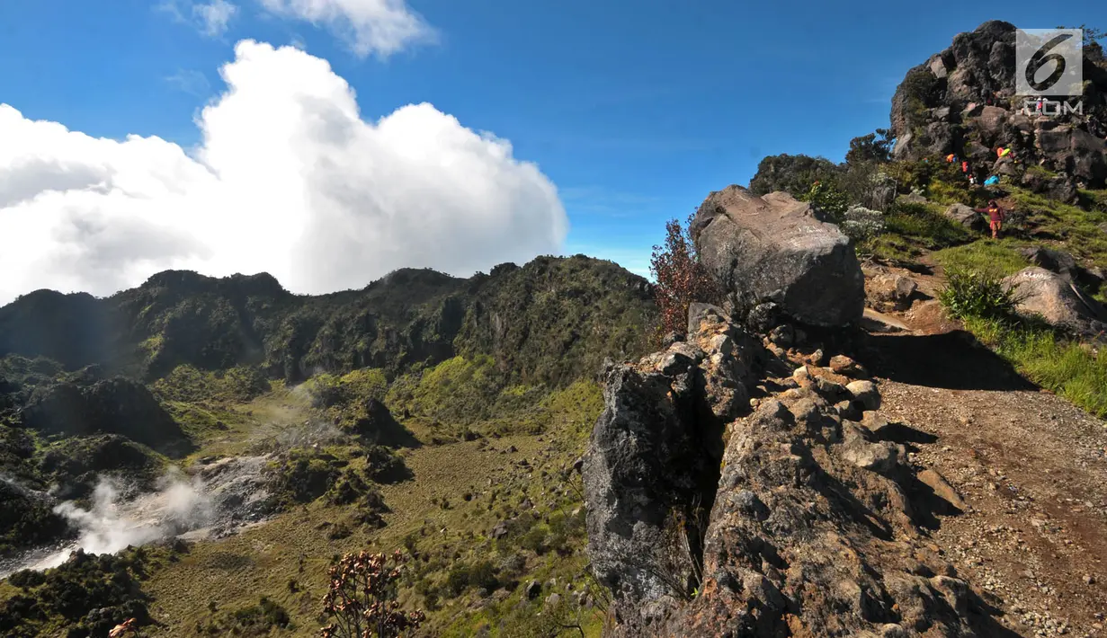 Pendaki memanjat tebing bebatuan saat menuju Puncak Rajawali dengan pemandangan kawah Gunung Sumbing di Wonosobo, Jawa Tengah (3/4). (merdeka.com/Iqbal S. Nugroho)