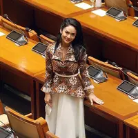 Krisdayanti tampil anggun dalam balutan kemeja batik peplum dan rok tutu putih tulang. Ia juga pakai high heels dan masker kain berbahan satin. (Instagram/krisdayantilemos).