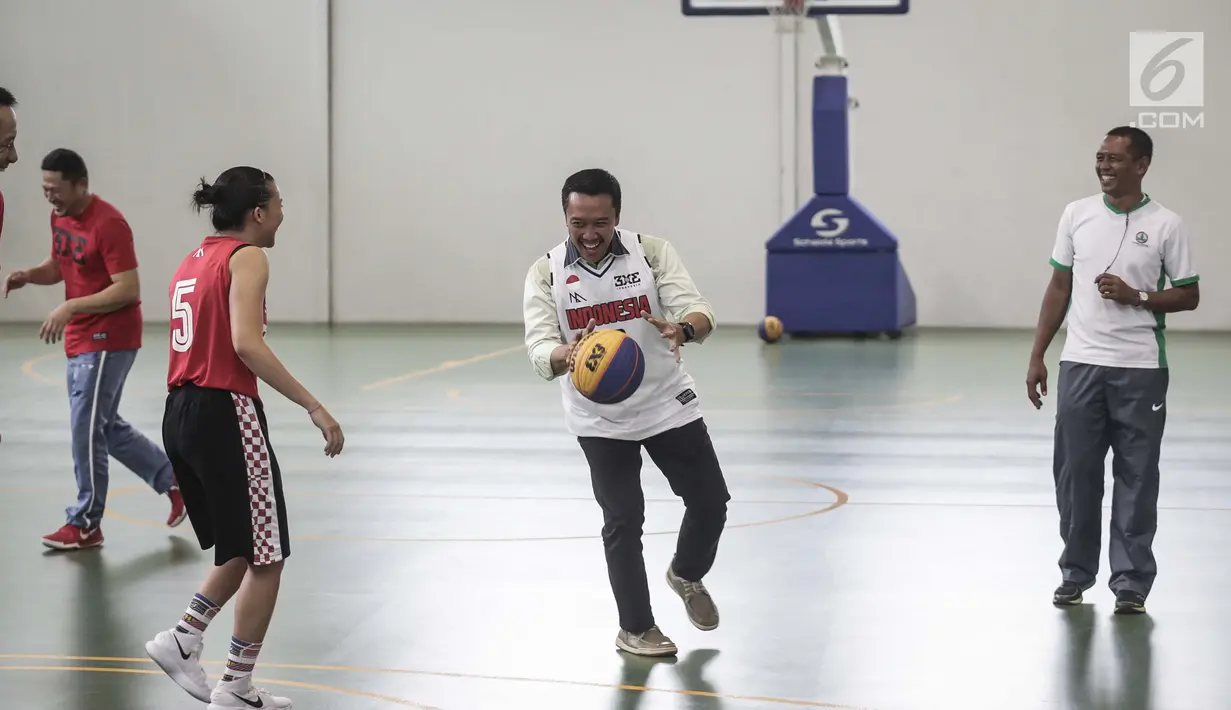 Menteri Pemuda dan Olahraga, Imam Nahrawi bermain basket di Lapangan Basket Istana Kana, Jakarta, Jumat (12/1). Menpora mengunjungi Pelatnas Asian Games 2018 cabang olahraga basket untuk meninjau kesiapan para atlet. (Liputan6.com/Faizal Fanani)