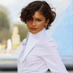 Zendaya melangkah ke show Louis Vuitton dengan potongan curly micro bob yang segar dan edgy.  [@zendayacit/@lesfacons].