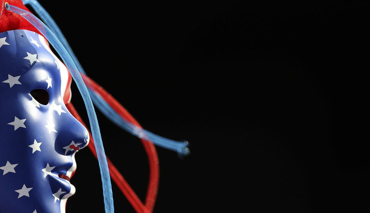 A fan for the U.S. wears a face mask in the U.S. colors prior to the Women's World Cup quarterfinal soccer match between France and the United States at the Parc des Princes, in Paris, Friday, June 28, 2019. (AP Photo/Francisco Seco)