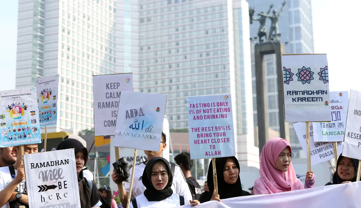 Sejumlah remaja mengangkat tulisan menyambut datangnya bulan Ramadan saat acara Car Free Day di Kawasan Bundaran Hotel Indonesia, Jakarta, Minggu (13/5). Mereka mengajak warga untuk menyambut bulan suci bagi umat muslim. (Liputan6.com/Helmi Fithriansyah)